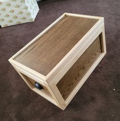 a wooden box sitting on the floor next to a christmas tree