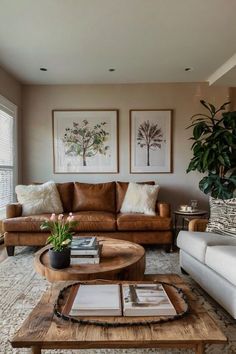 a living room with two couches, a coffee table and pictures on the wall