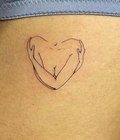 a woman's stomach with a heart tattoo on it