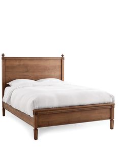 a wooden bed frame with white sheets and pillows