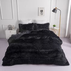 the bed is made with black fur and pillows