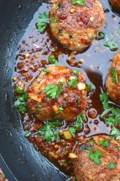 meatballs with sauce and parsley in a skillet