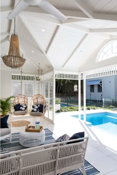 the inside of a house that has a pool and patio furniture in front of it