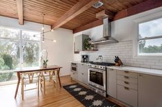 a kitchen with wooden floors and white walls, along with a dining table set for four