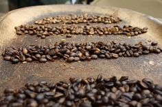 coffee beans are arranged in the shape of an arrow on top of a wooden table