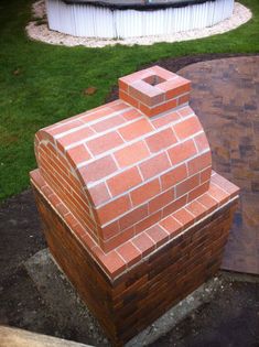 a brick oven sitting in the middle of a yard