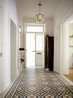 a hallway with a soccer ball on the floor and a light fixture hanging from the ceiling