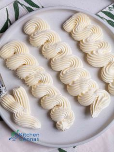 white frosted mering on a plate next to a knife