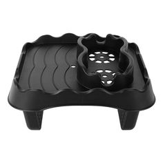 a black plastic tray with holes in the center and two sections on each side,