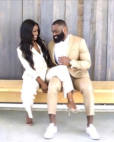 a man and woman sitting on a wooden bench