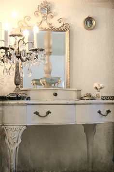 a white table topped with a mirror and a chandelier