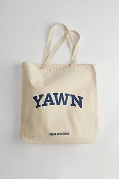 School spirit slogan tote bag by Urban Outfitters. Essential 12 oz. cotton canvas bag with carry handles & topped with a graphic print at the front. Features YAWN tote bag Campus slogan tote bag Front graphic print 12 oz. cotton canvas Classic single pocket Woven carry handles Content + Care 100% Cotton Spot clean Imported Size Dimensions: 15" w x 16" h x 3" d Handle drop: 21" | Urban Outfitters YAWN Tote Bag in Neutral, Men's at Urban Outfitters Brand Sale, School Spirit, Jeans For Sale, Canvas Bag, Color Coding, Graphic Prints, Cotton Canvas, 3 D, Urban Outfitters