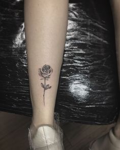 a woman's foot with a small rose tattoo on the left side of her leg