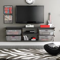 a flat screen tv mounted to the side of a wall next to a black chair