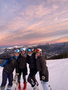 three skiers pose for a photo in the snow