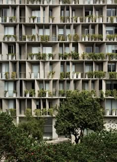 an apartment building with many balconies and plants growing on the side of it