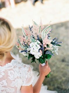 a woman holding a bouquet of flowers in her hand