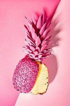 a pink and yellow pineapple cut in half