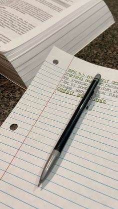 a pen sitting on top of a piece of lined paper