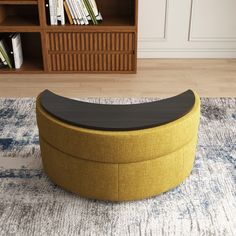 a yellow ottoman sitting on top of a rug in front of a book shelf filled with books