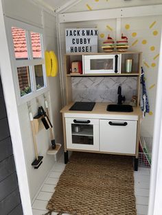 a small kitchen with white cabinets and yellow polka dot wallpaper on the walls, along with an area rug