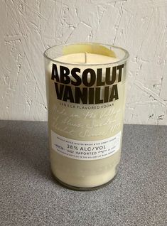 a candle that is sitting on a table with the words absolut vanilla in front of it