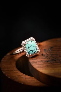 a turquoise ring sitting on top of a wooden table