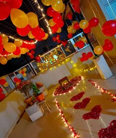 red and yellow balloons are floating in the air above a room with white flooring