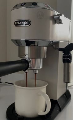 coffee being poured into a cup in front of an espresso machine