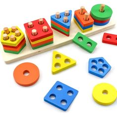 colorful wooden toys are arranged on a white surface