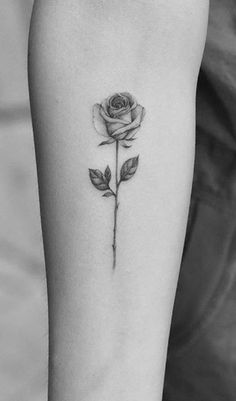 a black and white rose tattoo on the arm