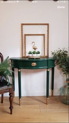 a green table sitting in the middle of a room next to a chair and potted plant