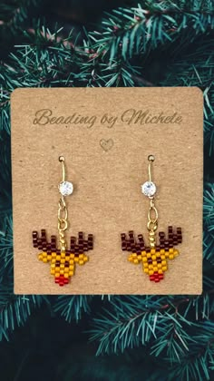 a pair of earrings that have been made out of legos and are hanging from a christmas tree