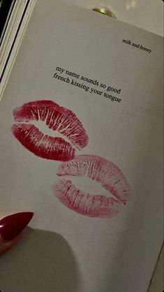 a woman's hand holding a book with two lipstick prints on it and the words, my love sounds to good french kissing your tongue