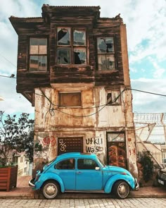 a small blue car parked in front of an old building