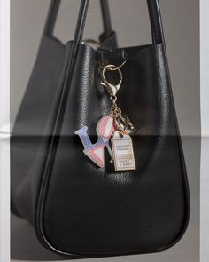 a black purse with a keychain hanging from it's front and side