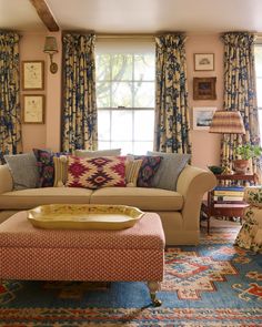 a living room filled with lots of furniture next to a window covered in drapes