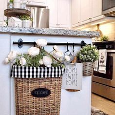 a basket with flowers hanging on the wall next to a stove top oven in a kitchen