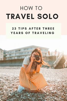 a woman sitting on the beach taking pictures with her camera, text reads how to travel solo