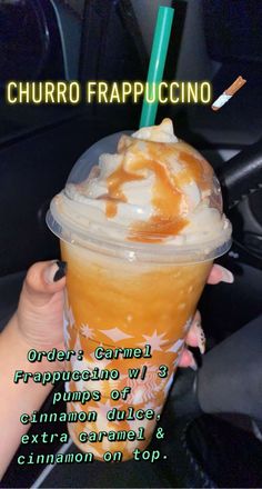 a person holding up a drink with caramel and whipped cream on top in a car