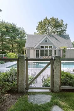 a house with a pool in the background and a fenced in area around it