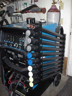 an array of electronic equipment sitting on top of a cart in a garage next to a wall