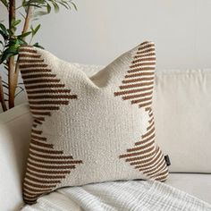 a white couch sitting next to a potted plant