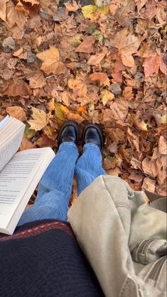 a person laying on the ground with their legs crossed and reading a book in front of them