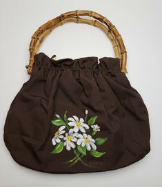 YOU ARE BUYING A BROWN FABRIC FLOWER PAINTED PURSE W/ BAMBOO HANDLES THE ITEM IS USED. THERE IS MINIMAL WEAR ON THE ITEM. THE ITEM MEASURES APPROX. 11.5IN WIDE, 9.5IN HIGH & 4.5IN THICK. THE DROP LENGTH IS 4.5IN LONG. PLEASE REVIEW PICTURES. ANY QUESTIONS PLEASE ASK. THANKS Sunflower Purse, Painted Purse, Jean Purse, Brown Bag, Brown Purses, Bamboo Handles, Fabric Flower, Brown Fabric, Fabric Paint