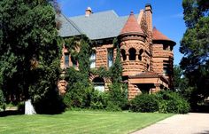 an old red brick building surrounded by greenery