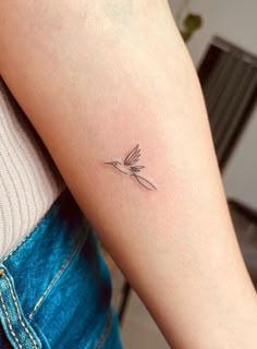 a small bird tattoo on the arm