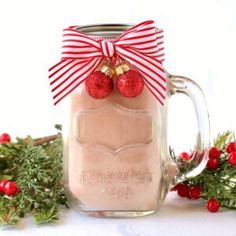 a mason jar filled with hot chocolate and topped with a red bow