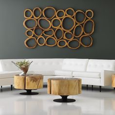 a living room filled with white furniture and wooden circles on the wall