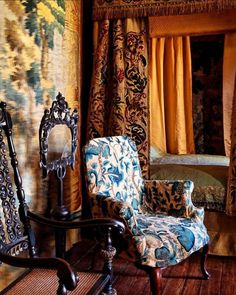 an ornately decorated bedroom with a canopy bed and blue chair in front of it